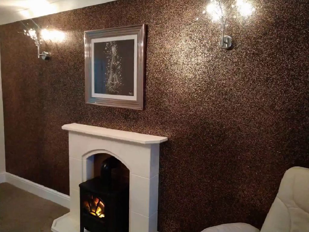 The bronze and black feature wall with the fireplace and wall lights