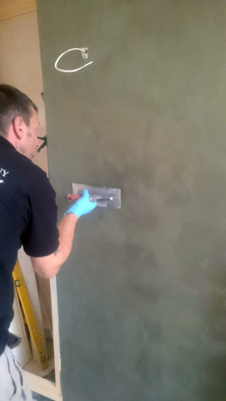 Applying Cadoro plaster to the wall with a trowel