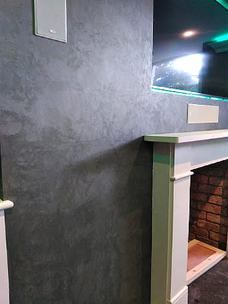 Close-up of the Cadoro texture beside the mantel and brick hearth