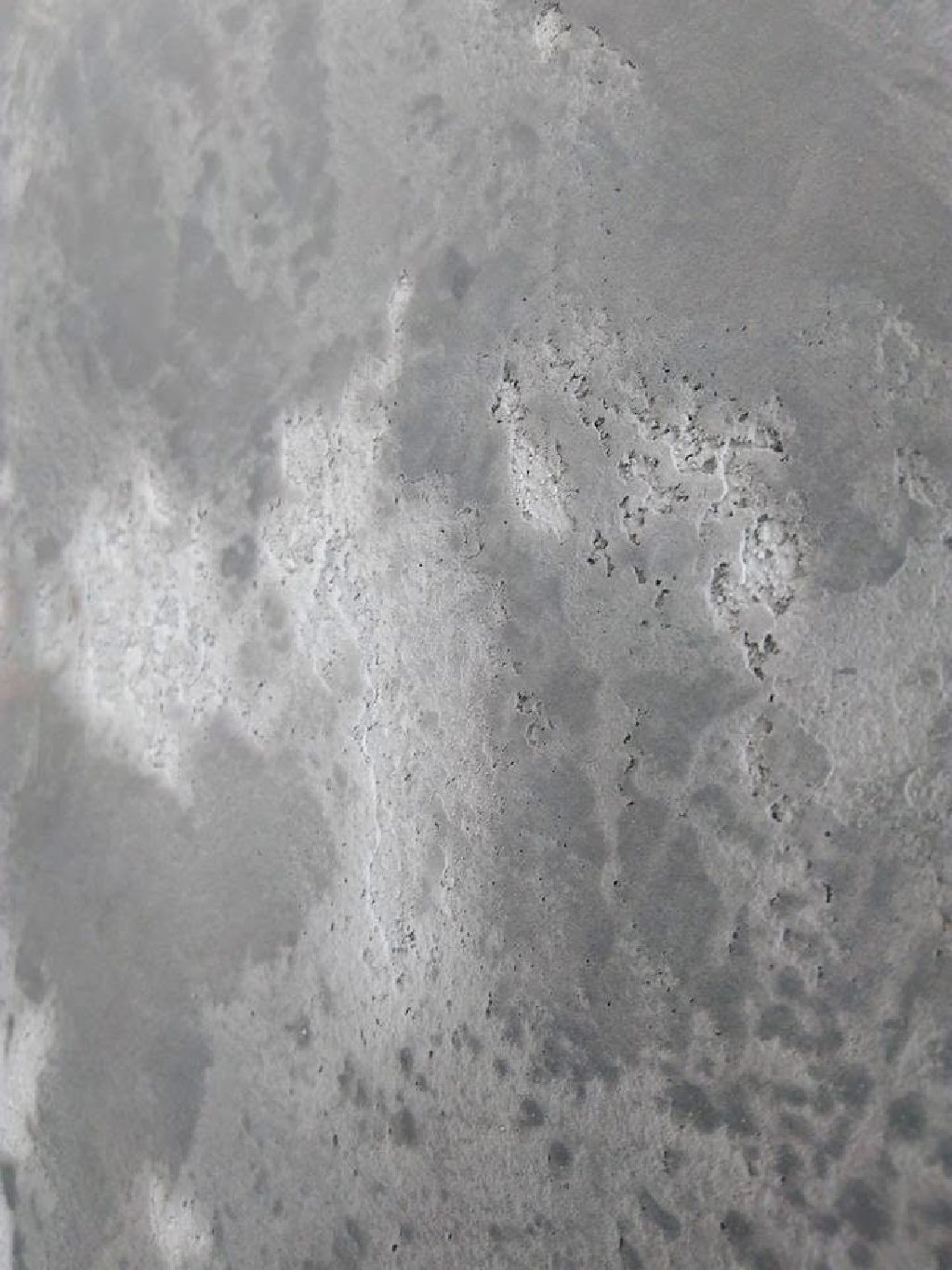 The weathered concrete effect up close — pitted texture under layers of grey wash