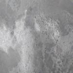 The weathered concrete effect up close — pitted texture under layers of grey wash