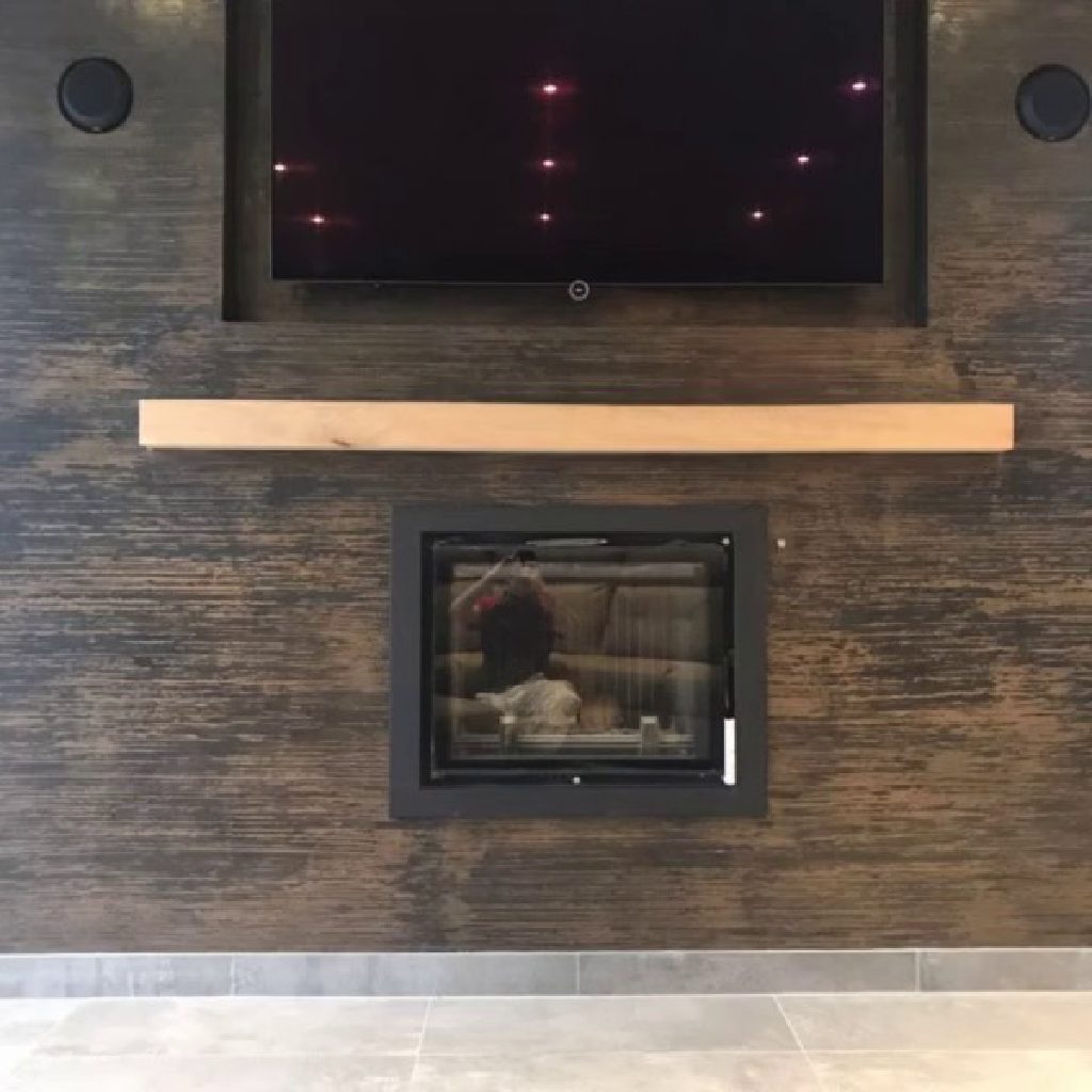 The fire and TV set flush into the black and bronze wall