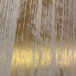 The finished panel seen along its length, gold flashing where the light strikes