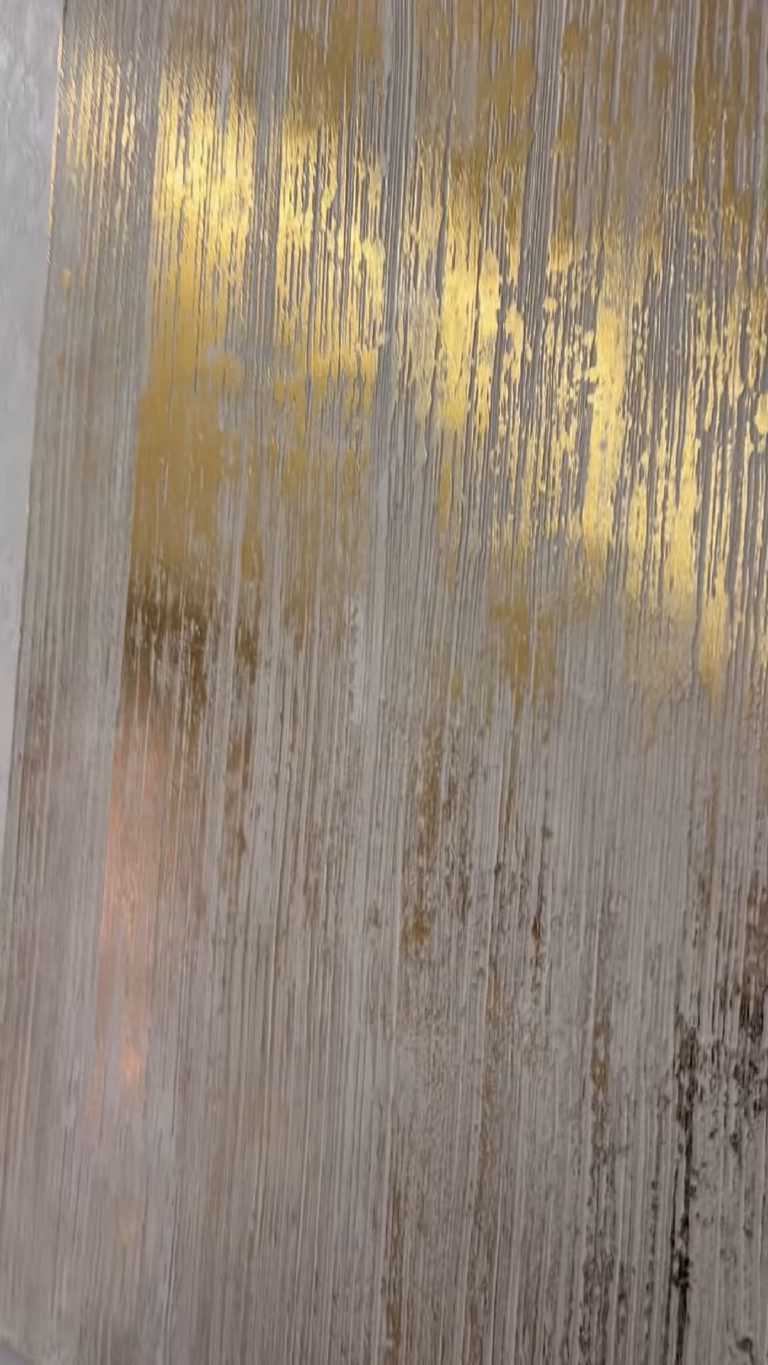 Gold caught along the raised combing with pale plaster in the hollows