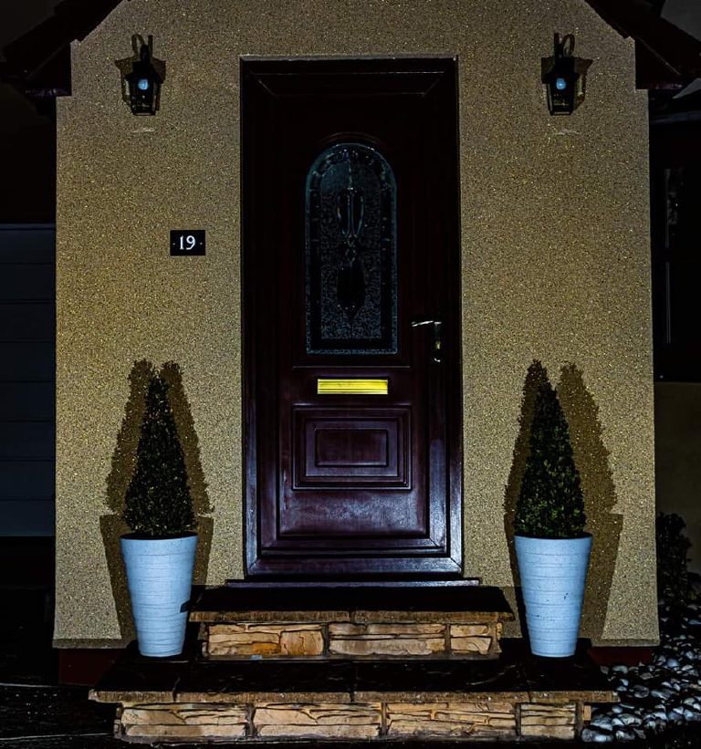 The porch after dark with the light raking across the wall and the gold flake lighting up across the whole surface