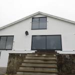 The finished gable elevation, bright white with new glass balconies