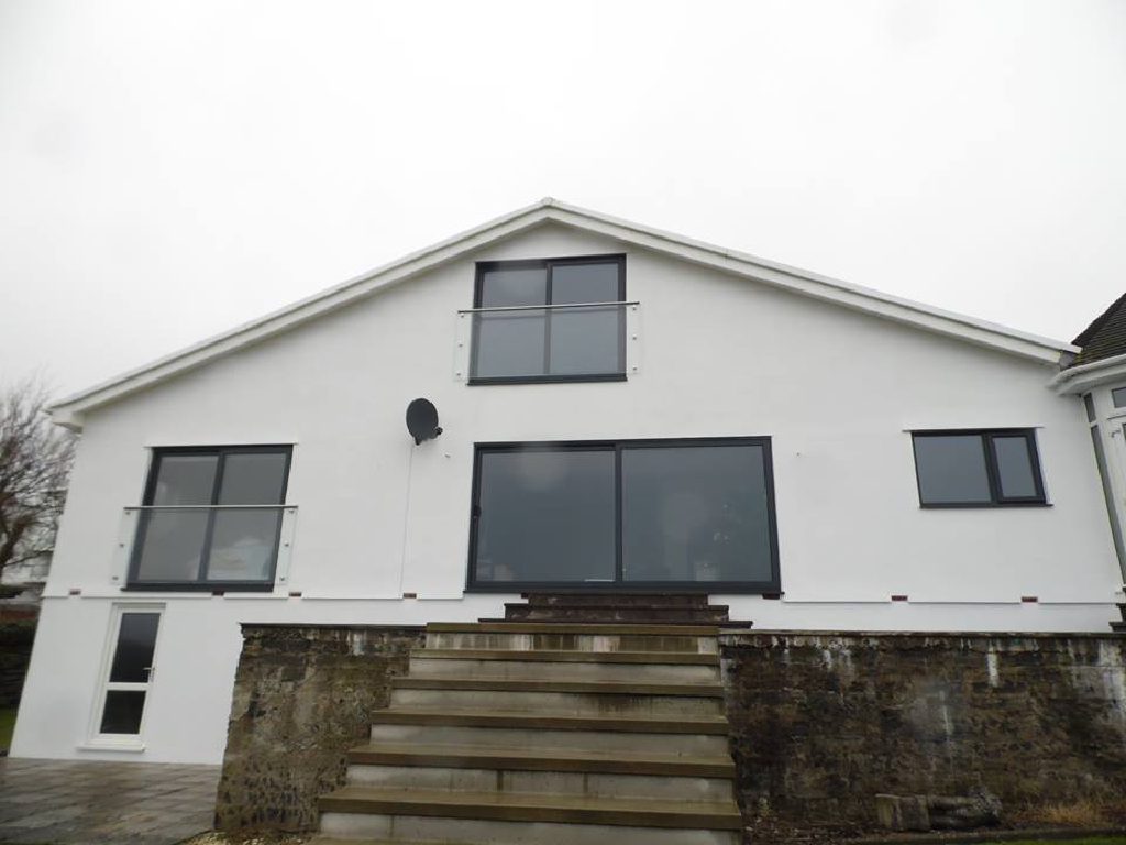 The finished gable elevation, bright white with new glass balconies