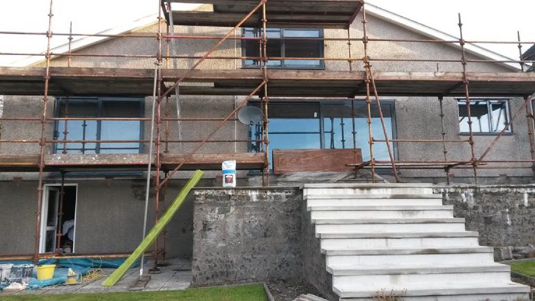 The original cracked 1970s dry dash behind the scaffold