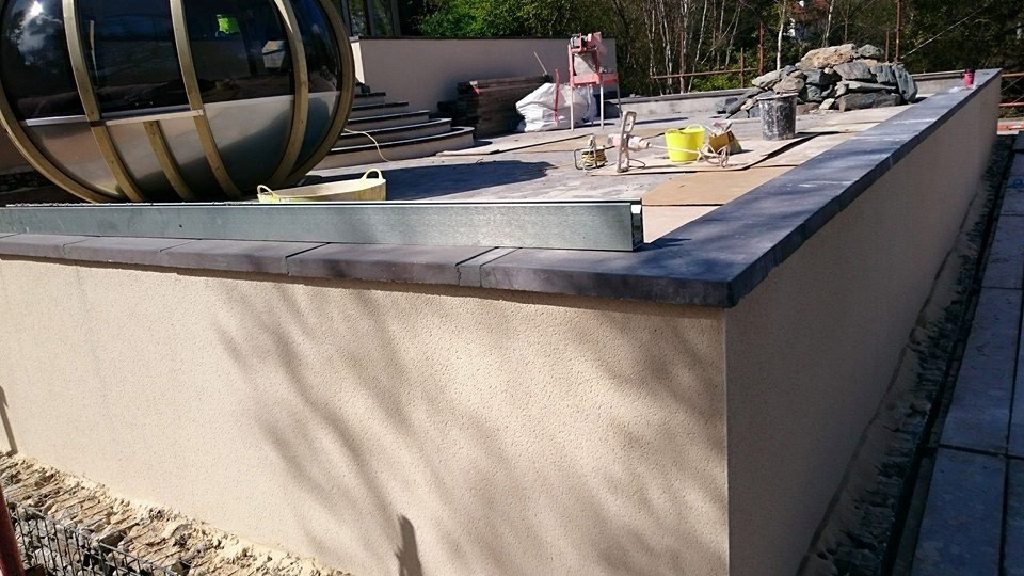 Garden wall finished in through-coloured Weber Rend under slate copings