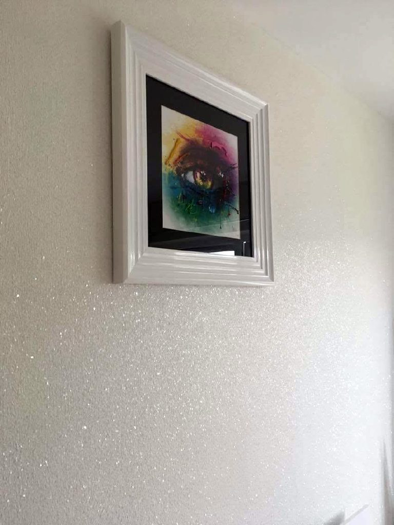 Artwork hung on the sparkling white glitter wall