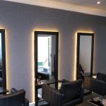 Three backlit mirrors set against the glitter feature wall