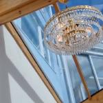 The crystal chandelier under the glazed roof, glitter wall lit up alongside it