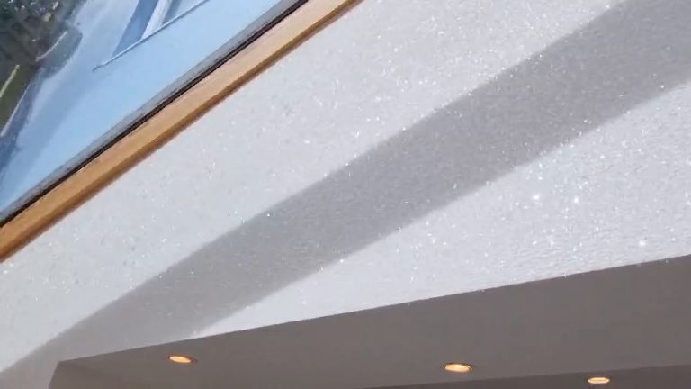 The glitter wall under the glazed roof with the row of downlights below