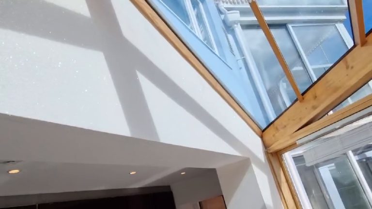 The room seen from below, vaulted glazed roof on oak beams over pale glitter walls