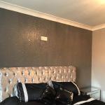 The grey glitter wall above the silver crushed velvet headboard