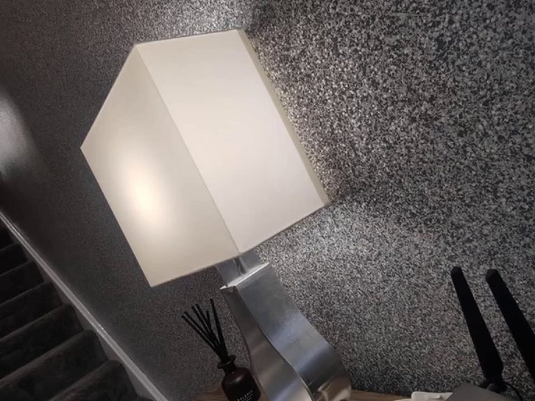 The corner of the room with a lamp lighting the glittered wall