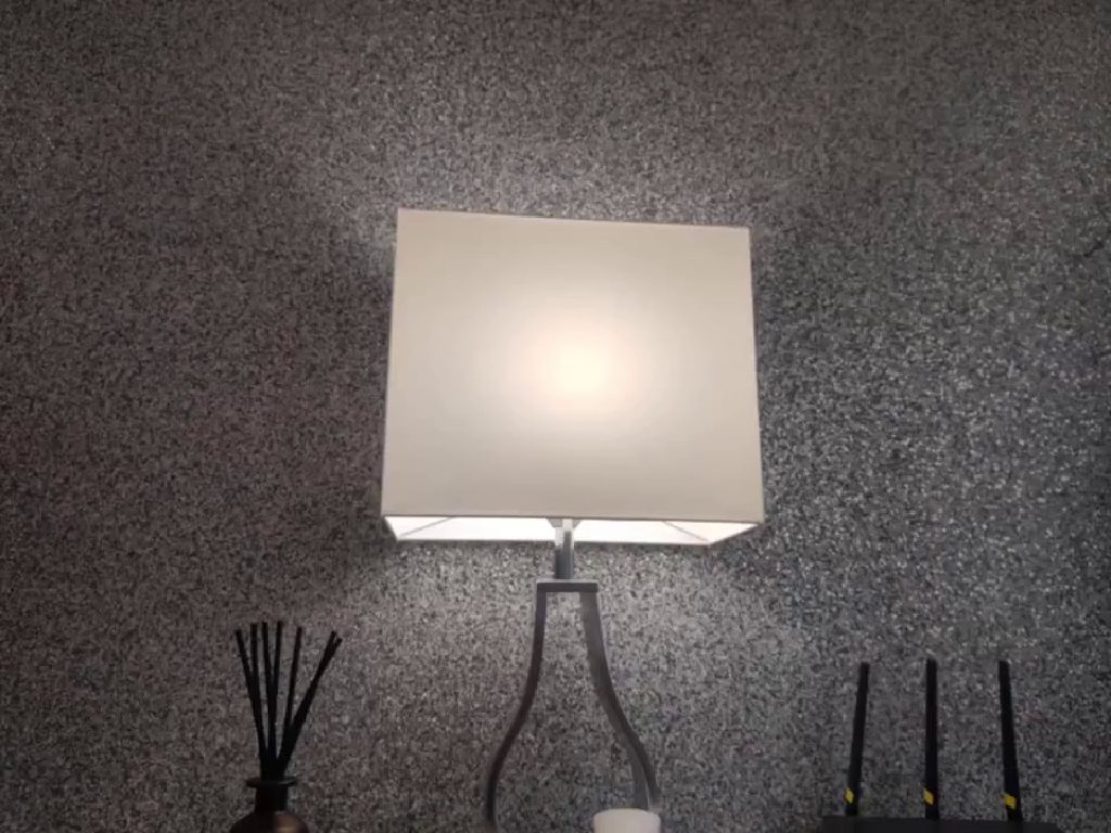 A wall light throwing light across the glitter finish