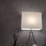 A wall light throwing light across the glitter finish