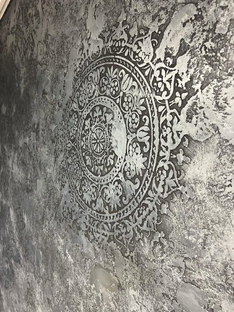 The stencilled medallion picked out in silver against the black Marmorino