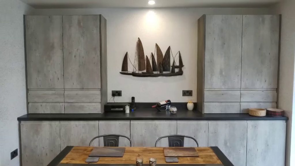 The Ilumitextra wall behind the dining table, between the tall units
