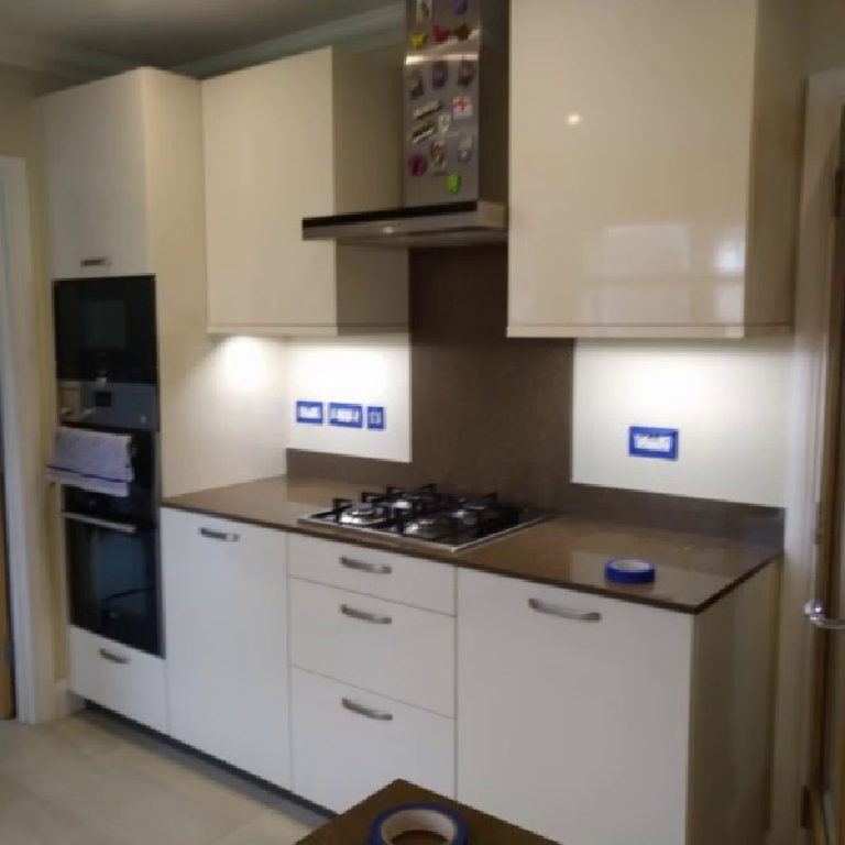 The kitchen before, with plain walls above the units and hob
