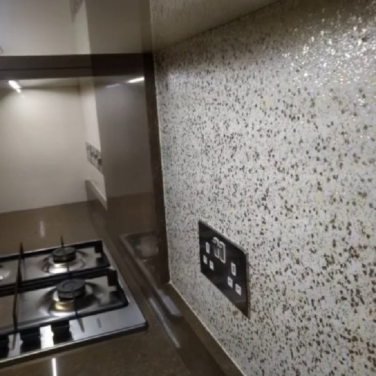 The glitter splashback beside the hob with the socket set into it