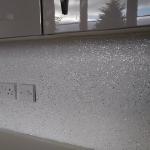 The silver and white flake wall below the gloss units