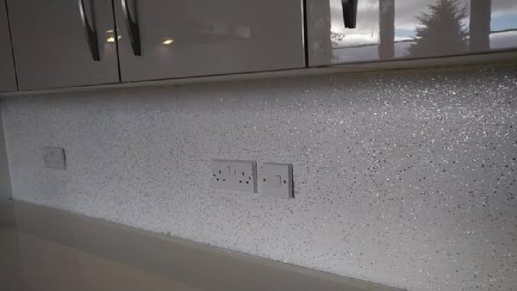 The silver and white flake wall below the gloss units