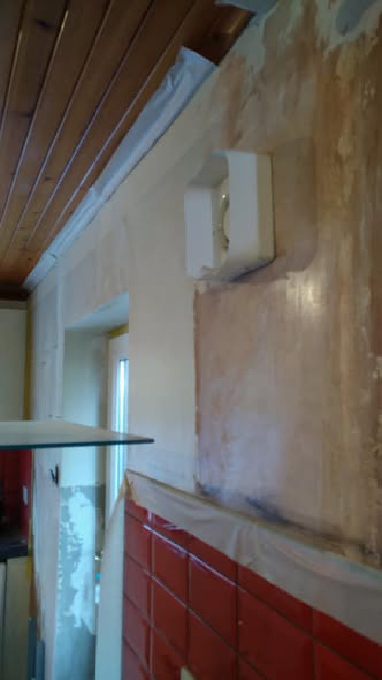 The tired, patched wall before its Ilumitextra coat