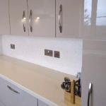 The white and silver Ilumitextra splashback below the gloss units