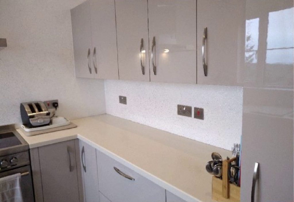 The white and silver Ilumitextra splashback below the gloss units
