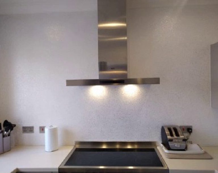 The glitter wall behind the hob catching the extractor lights