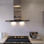 The sparkling wall behind the hob under the extractor lights