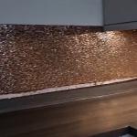 The splashback turning the corner with the light catching the copper