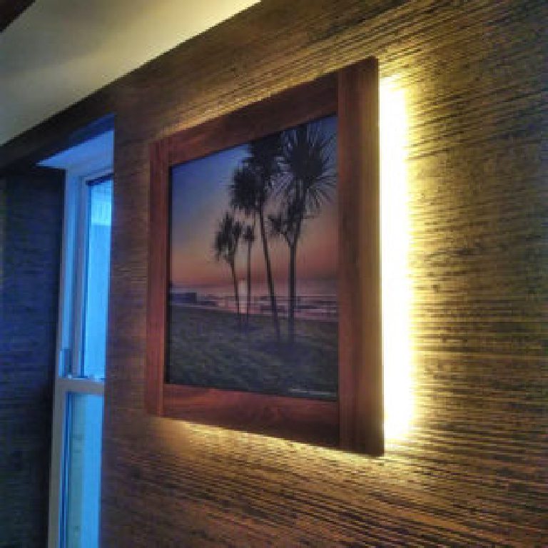 Backlit artwork mounted on the bronze dragged feature wall