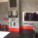 The Marmorino chimney breast and recessed TV above the red splashback