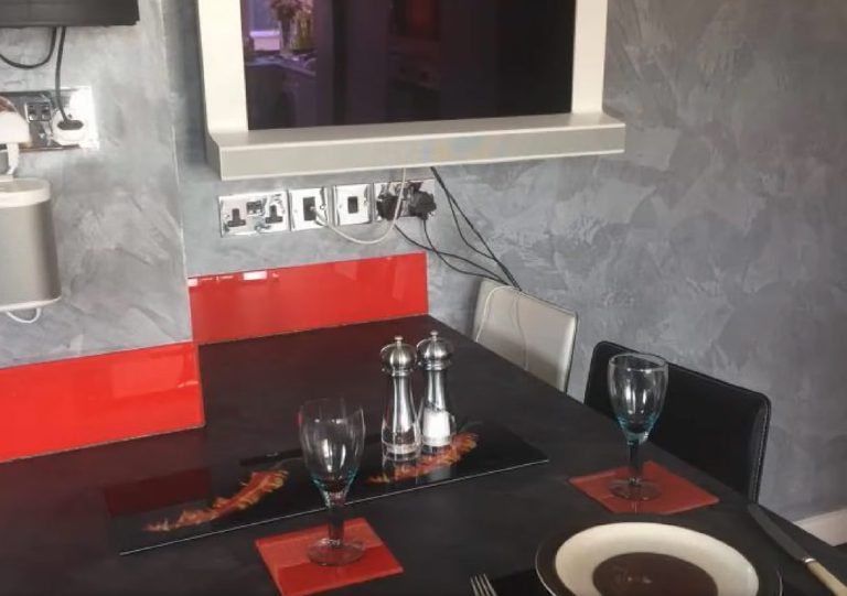 Dining corner with red glass splashback and Marmorino walls