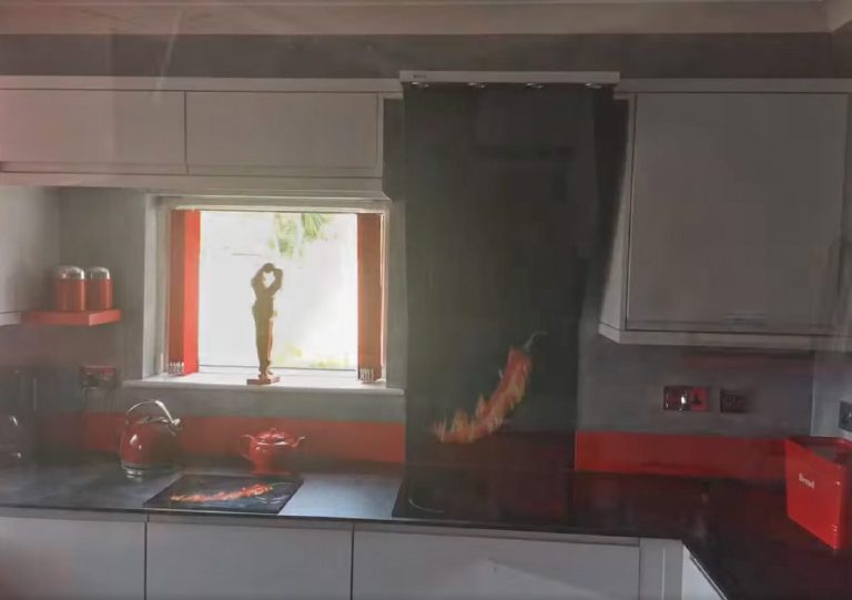 The window end of the kitchen with red kettle and teapot