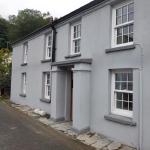 The finished front of the cottage in grey cork render, taken from the road below