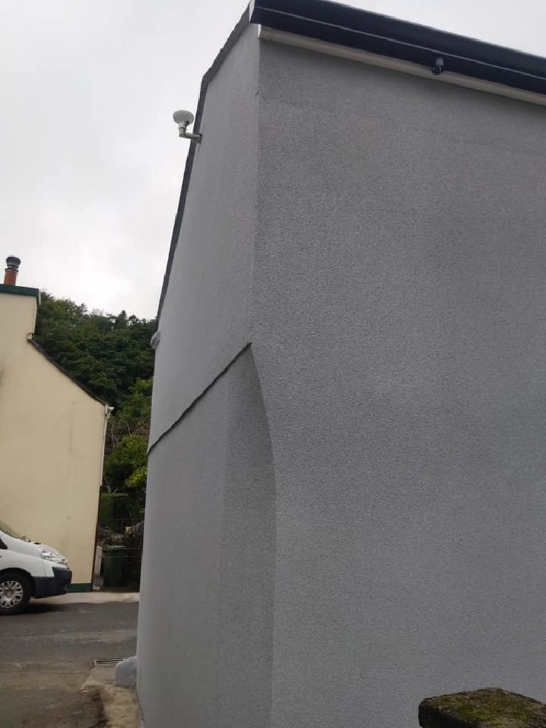 The gable end in grey cork render, a clean corner running the full height