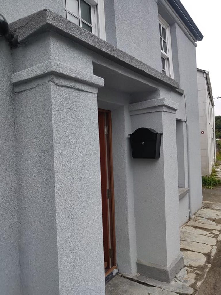 The porch after the work, cork render carried over the columns, caps and overhanging lintel