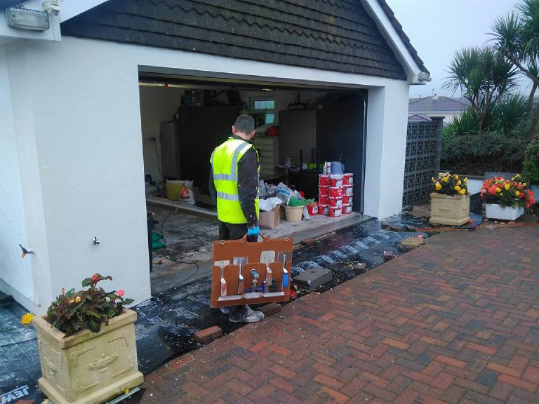 Materials stacked at the open garage on the drive