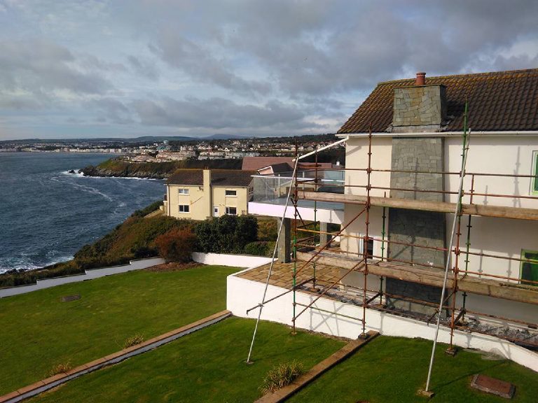 The house scaffolded on Onchan Head, the bay behind it
