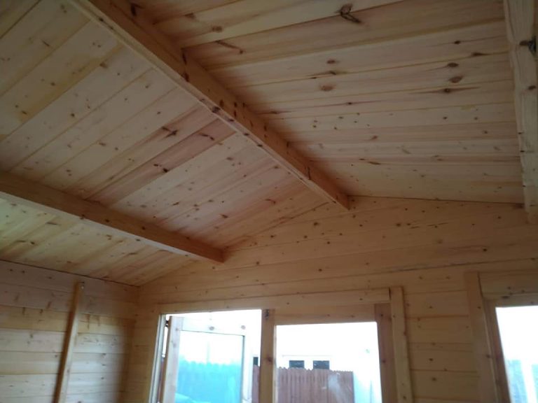 The bare timber roof and rafters inside the shed before spraying