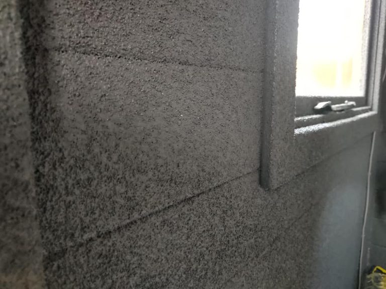Close-up of the dark sprayed cork with the timber board lines showing through