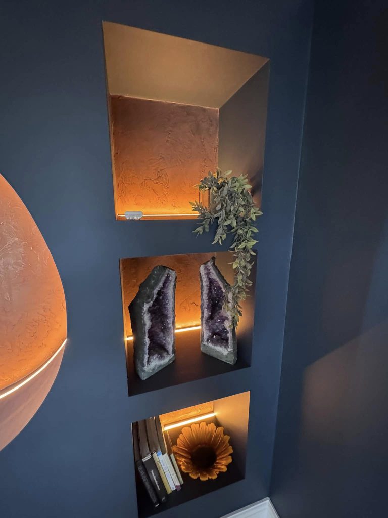 Three recessed niches lined in the same plaster, lit from within