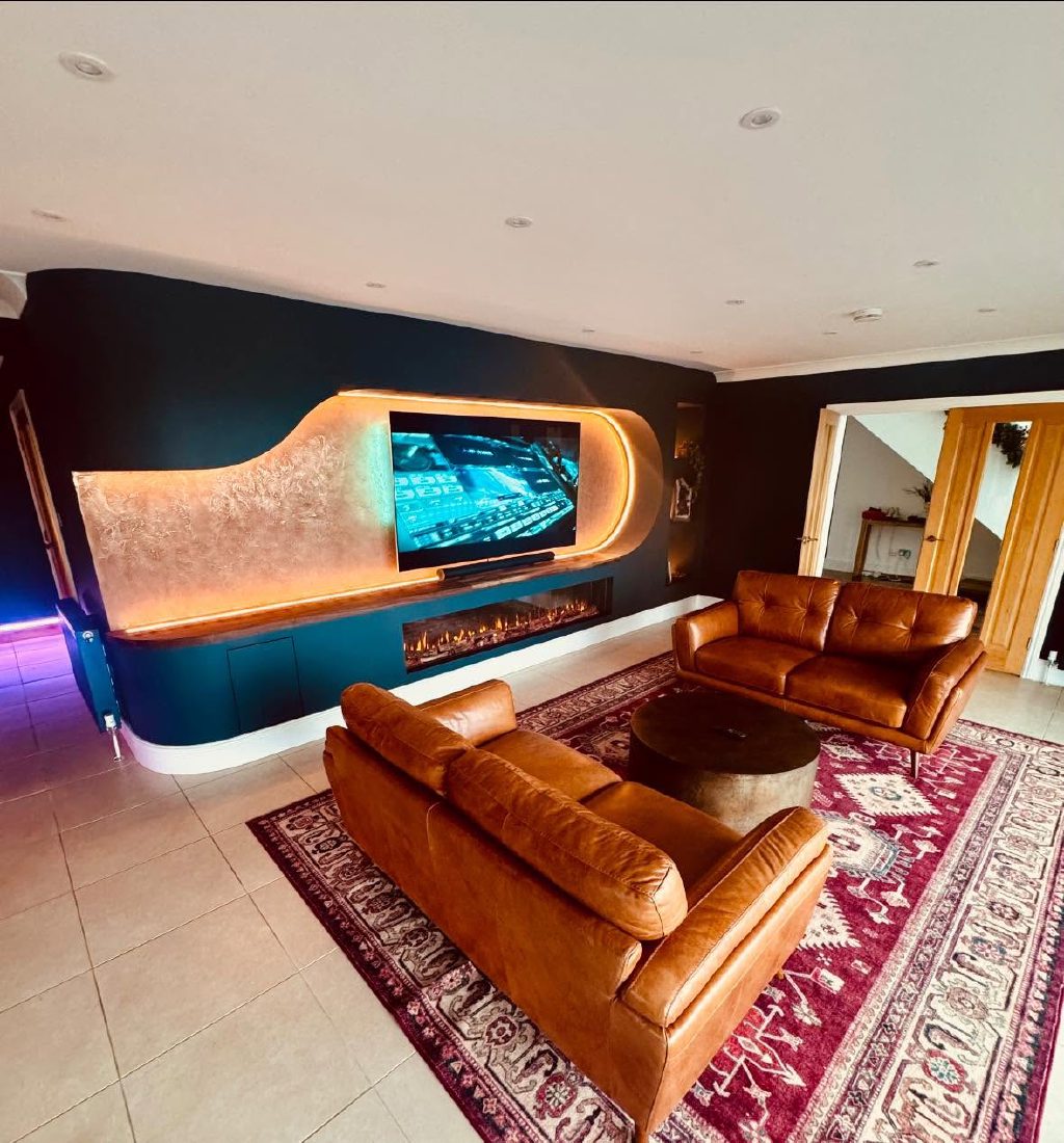 The media wall seen across the open-plan room, curving away towards the kitchen