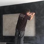 VPC craftsman working on the black Marmorino fireplace surround