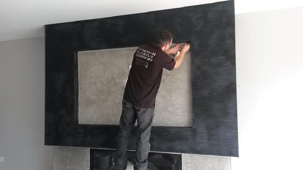 VPC craftsman working on the black Marmorino fireplace surround