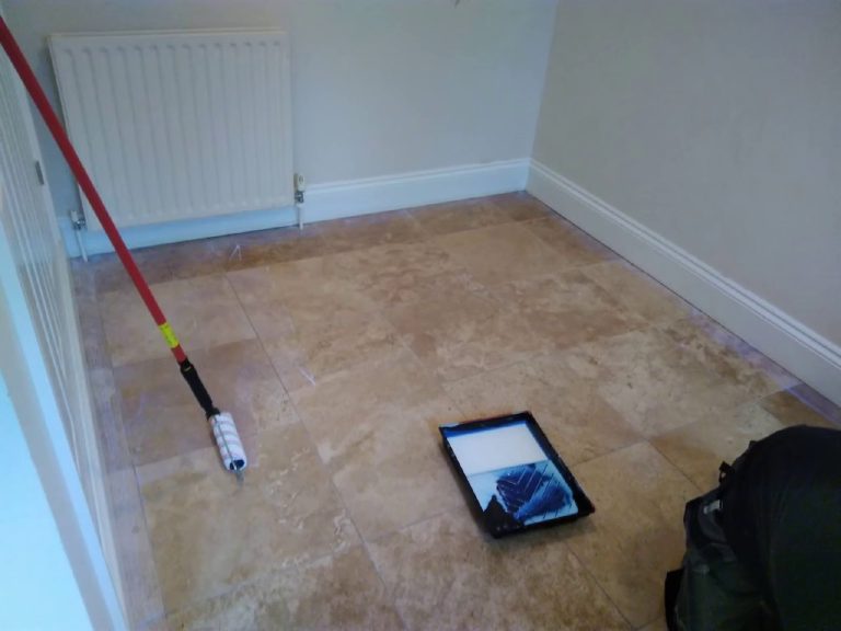 The old tiles being primed with a roller